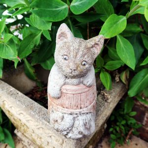 Vintage Cat in a Barrel Garden Ornament front facing with green leaves behind